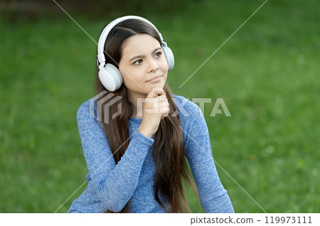 Music lifestyle. Teen girl listen music in wireless headphones outdoor. Gen z lifestyle. Music style. Stylish teen girl thinking and listen music. School student lifestyle. Listen audio. Copy space Music lifestyle. Teen girl listen music in wireless headphones outdoor. Gen z lifestyle. Music style. Stylish teen girl thinking and listen music. School student lifestyle. Listen audio. Copy space 119973111