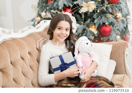 Holiday atmosphere. best christmas toy gift. cheerful kid find presents at christmas tree. feeling cosy at home. happy new year. cheer and joy. xmas presents at kid shop. small girl love her bunny Holiday atmosphere. best christmas toy gift. cheerful kid find presents at christmas tree. feeling cosy at home. happy new year. cheer and joy. xmas presents at kid shop. small girl love her bunny 119973510