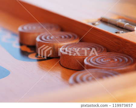 Wooden game pieces arranged neatly on a traditional backgammon game board Wooden game pieces arranged neatly on a traditional backgammon game board 119973657