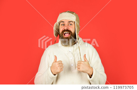 portrait of trendy guy wearing hat. Male winter style. Modern winter earflap beanie hat. Funky happy bearded man. mature man posing with funny outfit. man beard in winter hat 119973705