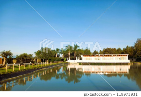 White gazebo on a lake in the park 119973931