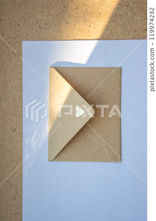 A delicate envelope with a heart design partially opened on a light surface during daylight 119974282
