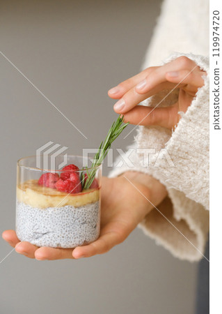 Delicious passion fruit and banana smoothie with raspberries in a glass on your hand 119974720