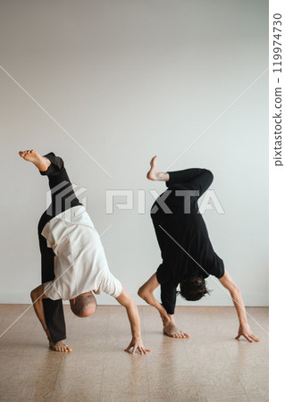 two young athletes practice yoga in the gym. Joint training, indoors, studio. The concept of a healthy lifestyle 119974730