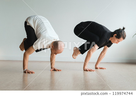 two young athletes practice yoga in the gym. Joint training, indoors, studio. The concept of a healthy lifestyle 119974744