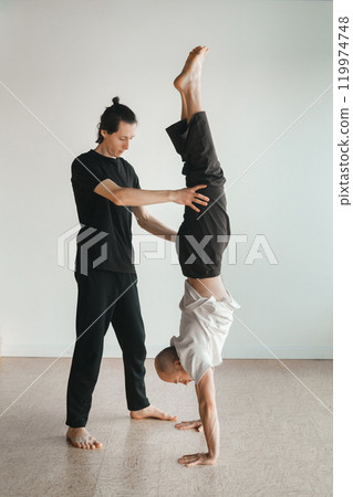 two young athletes practice yoga in the gym. Joint training, indoors, studio. The concept of a healthy lifestyle 119974748