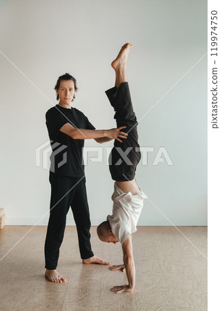 two young athletes practice yoga in the gym. Joint training, indoors, studio. The concept of a healthy lifestyle 119974750