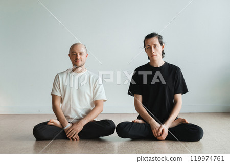 two young athletes practice yoga in the gym. Joint training, indoors, studio. The concept of a healthy lifestyle 119974761