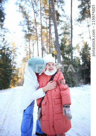 a mother lovingly embracing her children against the backdrop of a beautiful winter forest. a mother lovingly embracing her children against the backdrop of a beautiful winter forest. 119974805