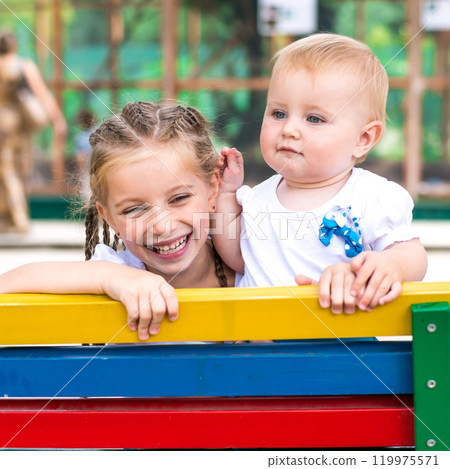 Two little sisters smiling with the park 119975571