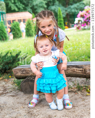 Two little sisters with the park 119975572