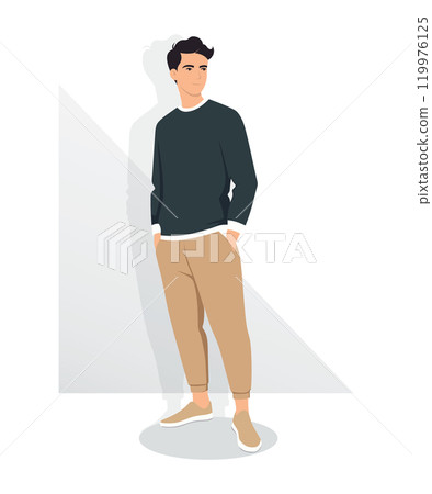A young man in a dark gray sweater and light brown trousers stands in a relaxed pose. 119976125