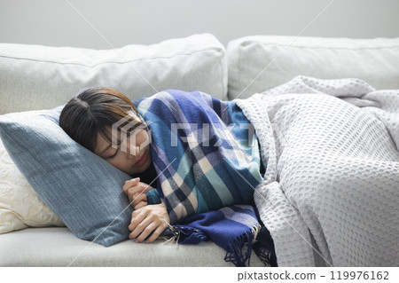 Woman feeling unwell in living room in winter 119976162