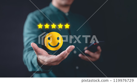 Customer show virtual screen on smile face icon with five stars. Business concept of testimonial customer service and feedback, good, the best of product and service. Best excellent services rating. Customer show virtual screen on smile face icon with five stars. Business concept of testimonial customer service and feedback, good, the best of product and service. Best excellent services rating. 119976729