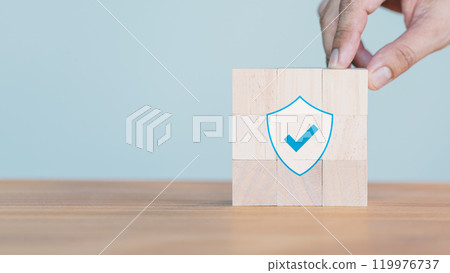Hand put a wooden cube block with identity proof icon for security protection system on wood table. Certified guarantee approval or secure access system concept. Quality assurance of business service. 119976737
