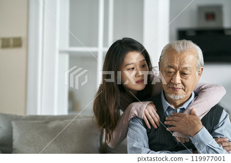 young asian adult daughter conforting senior father at home young asian adult daughter conforting senior father at home 119977001