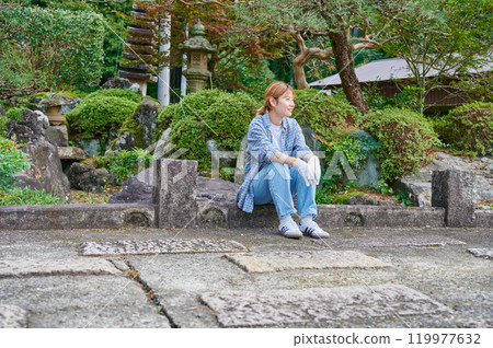 Woman gardening an old house - Country living Woman gardening an old house - Country living 119977632