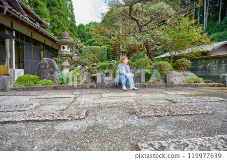 Woman gardening an old house - Country living Woman gardening an old house - Country living 119977639