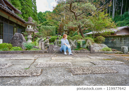 Woman gardening an old house - Country living Woman gardening an old house - Country living 119977642