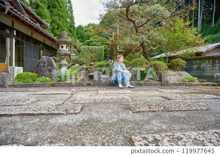 Woman gardening an old house - Country living Woman gardening an old house - Country living 119977645