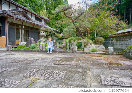 Woman gardening an old house - Country living Woman gardening an old house - Country living 119977664
