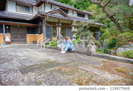 Woman gardening an old house - Country living Woman gardening an old house - Country living 119977669