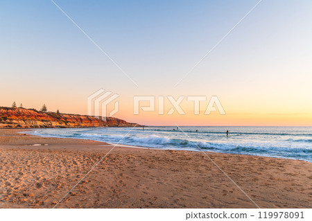 People surfing and paddleboarding at Southport beach 119978091