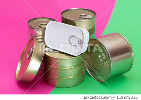 A Group of Stacked Tin Cans on Split Green and Cyan Background 119978316