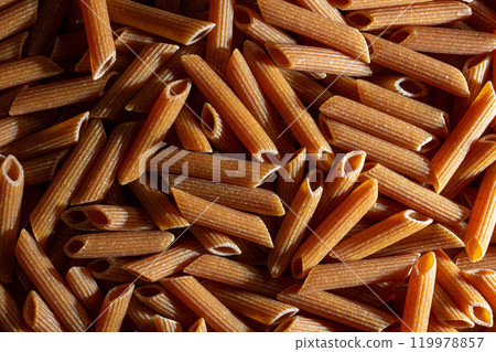 Uncooked Whole Grain Penne Rigate Pasta Background 119978857