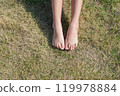 Child's feet on the grass 119978884