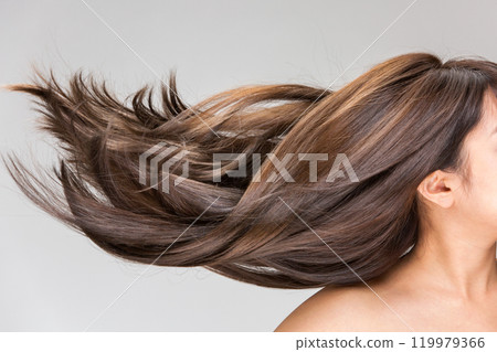 Close-up of a young woman's shiny, flowing hair. 119979366