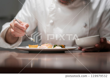 Male chef preparing a dish Male chef preparing a dish 119979532
