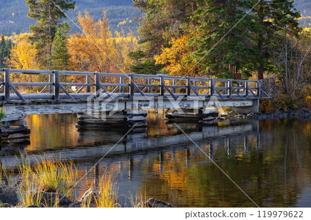 Wooden bridge across the lake to the little island in mountains. 119979622