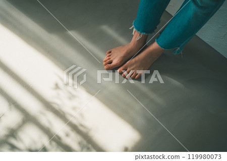 Barefoot woman and window light 119980073