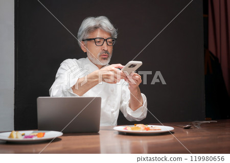 廚師透過查看電腦來提高烹飪水平 119980656