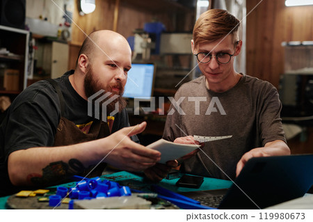 Two engineers discussing online data 119980673