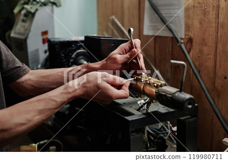 Hands of repairman fixing small details Hands of repairman fixing small details 119980711
