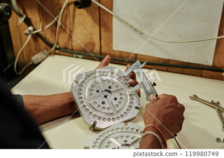 Worker measuring press mold with caliper Worker measuring press mold with caliper 119980749