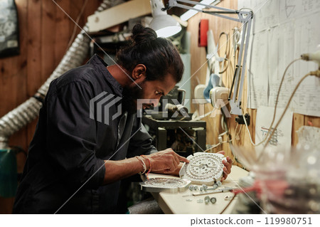Man pointing at press mold by workbench 119980751