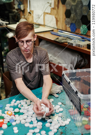 Man sorting polyethylene bottle caps Man sorting polyethylene bottle caps 119980772