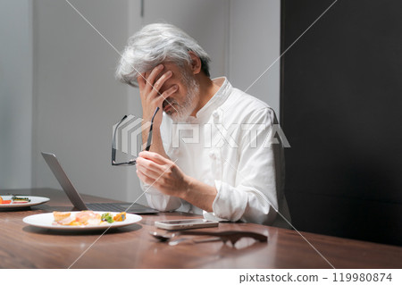 A chef improves a dish by looking at a computer 119980874