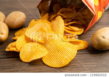 Potato chips, delicious BBQ seasoning spicy for crips, thin slice deep fried snack fast food in open bag. Potato chips, delicious BBQ seasoning spicy for crips, thin slice deep fried snack fast food in open bag. 119982010