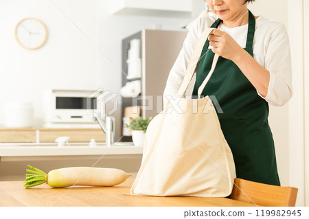 一位中高級婦女在家中客廳從包包裡取出食材 119982945