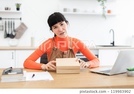 Young woman preparing for online business with packaging on desk Young woman preparing for online business with packaging on desk 119983902