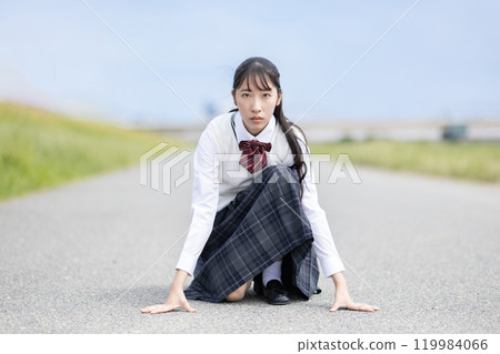 High school girl preparing for a crouching start 119984066