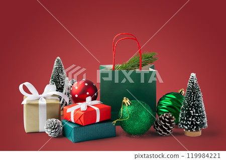 Christmas gift box and present with green christmas ball and decor on red background 119984221