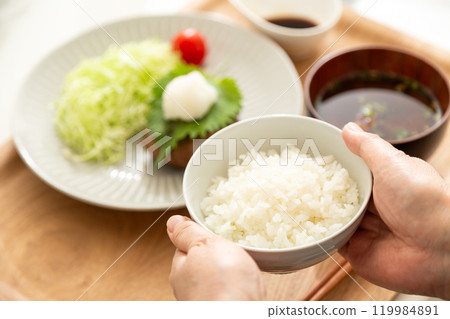 The hands of a middle-aged to senior woman serving food The hands of a middle-aged to senior woman serving food 119984891