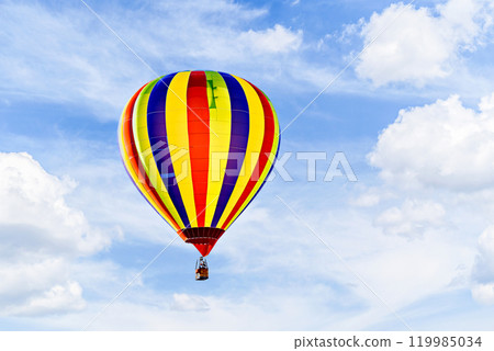 Colorful hot air balloon flying over blue sky with white clouds Colorful hot air balloon flying over blue sky with white clouds 119985034
