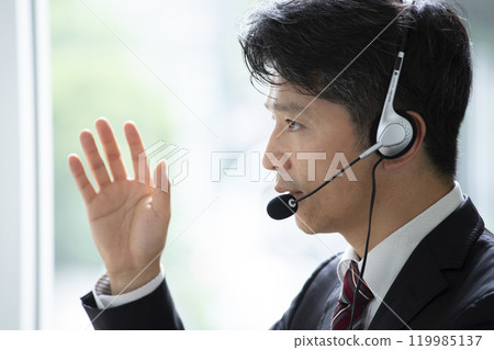 A man wearing a headset at work A man wearing a headset at work 119985137