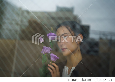 A young woman in a suit with a melancholy expression and a cityscape reflected through the glass A young woman in a suit with a melancholy expression and a cityscape reflected through the glass 119985493